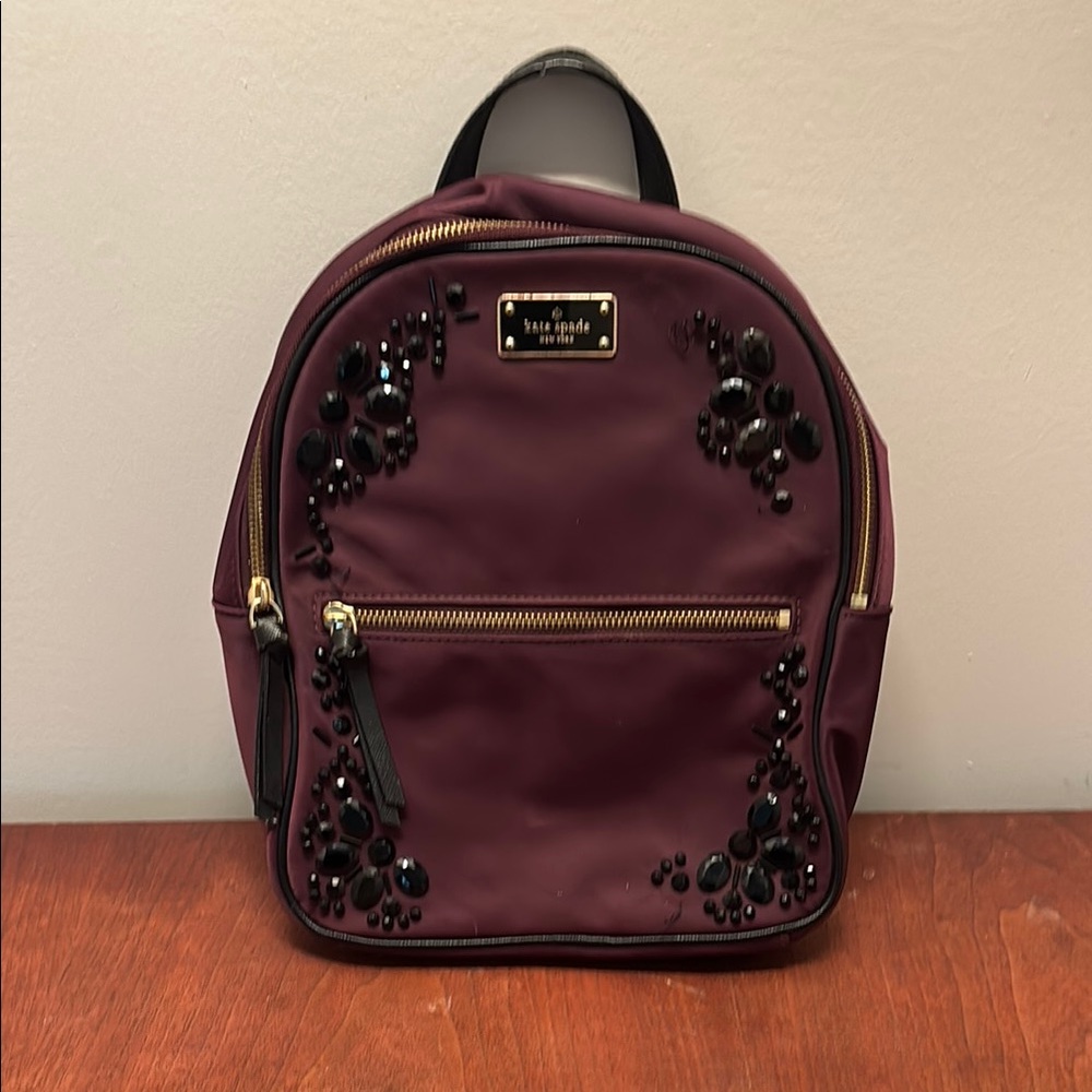 Kate Spade Burgundy Backpack with Black Embellishments